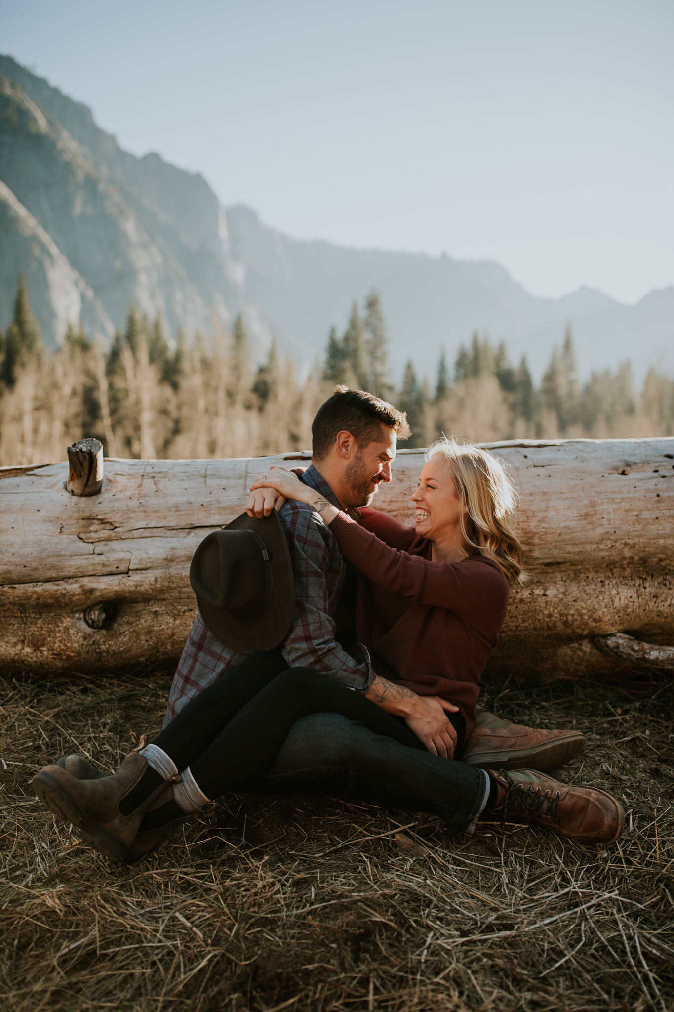 young couple cuddle together and laugh in Yosemite valley